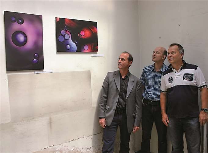 "Entdeckung von Phantasie ohne Grenzen" Nikolaus Wilhelmy mit den Organisatoren der Ausstellung Thomas (M.) und Christoph (r.) Zimmermann vor zwei der beeindruckenden KunstPhotografien. RÜ