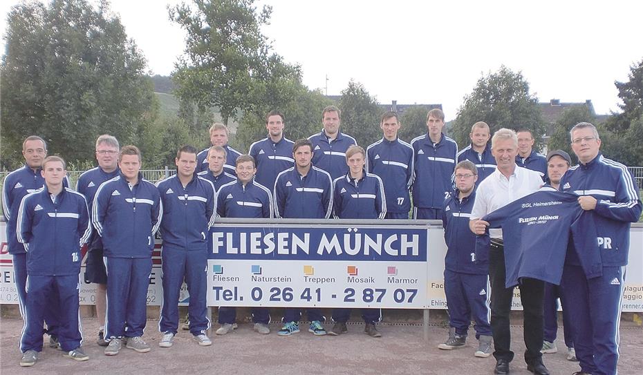 Norbert Münch überreicht neue Trainingsanzüge für das Team