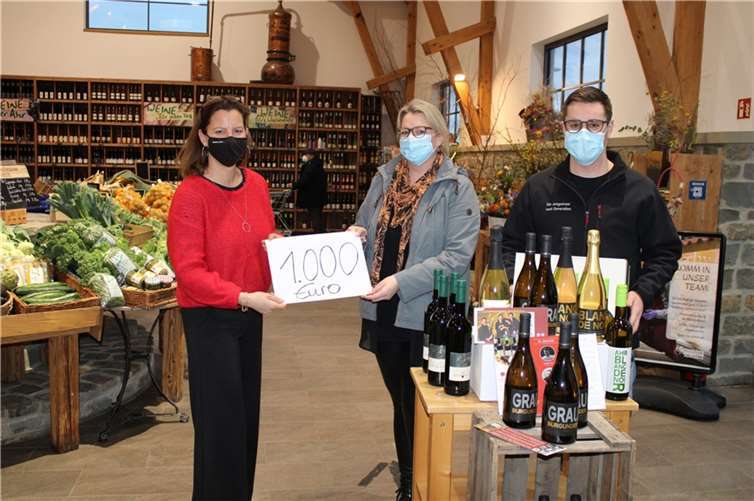 1.000 Euro spendeten die Jungwinzer „The next Generation“ und „Schneiders Marktscheune“ an die stark Flut-betroffene Philipp Freiherr von Boeselager Realschule plus in Bad Neuenahr-Ahrweiler, von links Béatrice Schneider (Schneiders Marktscheune), Dorthee Hölters (SV-Lehrerein Philipp Freiherr von Boeselager Realschule plus) und Niklas Körtgen (Jungwinzer „The next Generation). Foto: DU