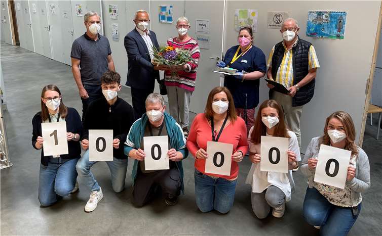 100.000. Impfungen am IZ in Oberhonnefeld: Hannelore Schaback (hinten Mitte) ließ sich den Jubiläums-Pieks vonder medizinischen fachangestellten Anke Marmé (2. von rechts) verabreichen und bekam zusätzlich vonLandrat Achim Hallerbach einen Blumenstrauß. Hallerbach dankte vor allem den fleißigen Mitgliedern des IZ-Teamsum den stellvertretenden Leiter Stefan Roos (links) für ihren Einsatz. Kurz nach Hannelore Schaback war auch ihrMann Hans-Wilhelm (rechts) an der Reihe. Für das Ehepaar war es die zweite Impfung. Quelle: Kreisverwaltung