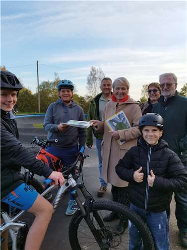 400 Unterschriften haben die Jugendlichen gesammelt, um ihrem Anliegen, ein Pumptrack in Montabaur, Nachdruck zu verleihen. Beim Besuch der Anlage in Herrschbach übergaben sie Unterschriften an Gabi Wieland und die mitgereisten Ratsmitglieder.  Foto: VG Montabaur / Larissa Metz