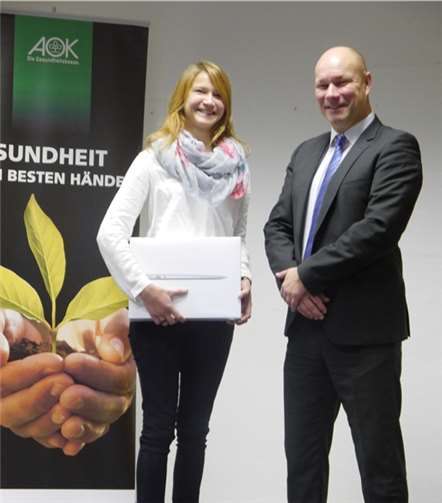 AOK-Bezirksgeschäftsführer Christoph Loersch (re.) überreichte Kerstin Goeres das MacBook Air 13. AOK