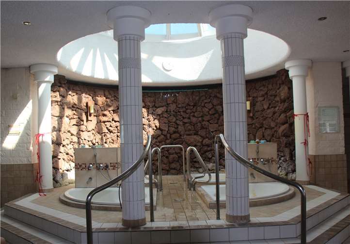 Abgetrennt durch vier Säulen und mit einem eigenen Glaskuppeldach: Die Braune Grotte mit den vier Badewannen, in denen man das naturbelassene Thermalwasser genießen kann.