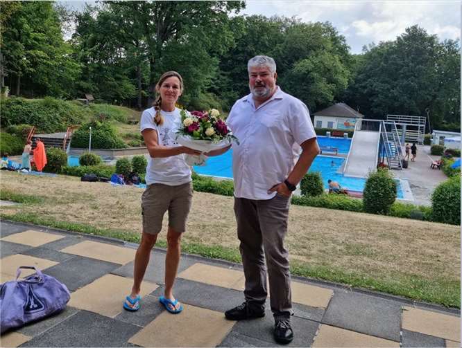 Achim Grün (1. Beigeordnete der Stadt Mendig) überreicht einen Blumenstrauß an Sandra Lentes, der 15.000sten Besucherin des Vulkanbades. Foto: privat