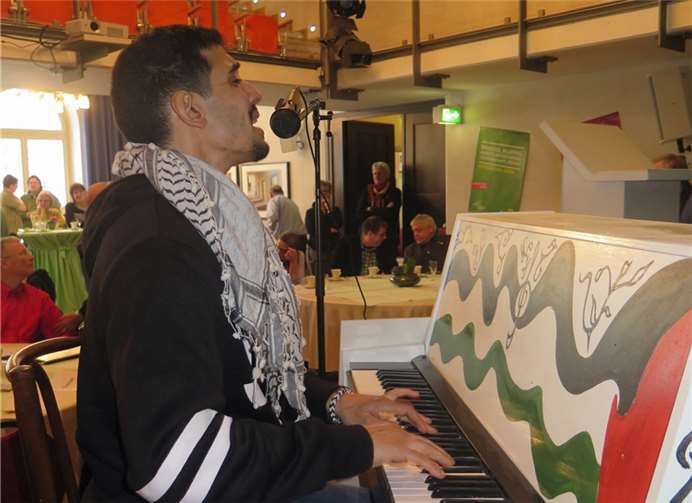 Aeham Ahmed an seinem Klavier, das er wie sein ursprüngliches Klavier bemalt hat.Privat