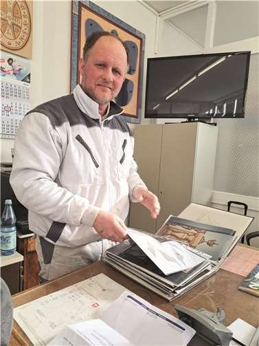 Albert Groz präsentiert in seiner 2004 gegründeten Firma zwei prall gefüllte Aktenordner mit zahlreichen Fotos von seinen eigens gefertigten Exponaten.