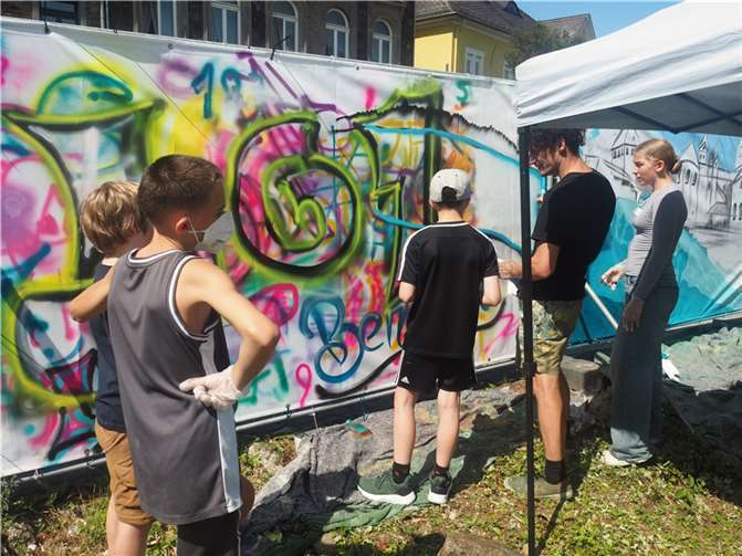 Alex „Moha“ Heyduczek im Austausch mit jungen Teilnehmenden des Graffiti-Workshops.