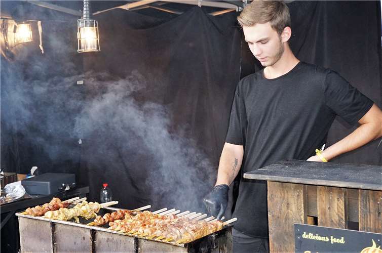 Alex grillt die Schaschlik-Spieße nach russischem Rezept vor den Augen der Besucher.