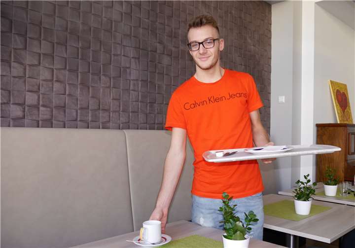 Alexander Seibert serviert Getränke und Speisen im Wohnzimmer des Hospizes.Hospiz im Ahrtal gGmbH