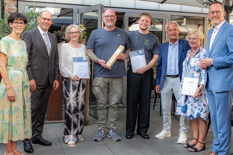 Alexandra Bardjasteh und Dirk Mayer-Mallmann (l.) und Michael Ebling, Minister für Wirtschaft, Tourismus, Energie und Klima des Landes Rheinland-Pfalz (r.) überreichten den Ehrenpreis 2026 an Marcel Lossie (Mitte) Das Ehepaar Martina & Norbert Wittenberg (2.+3.v.r.) sowie Regina Witzel für Dr. Nikolaus Förster (3.v.l.) werden ebenfalls ausgezeichnet.