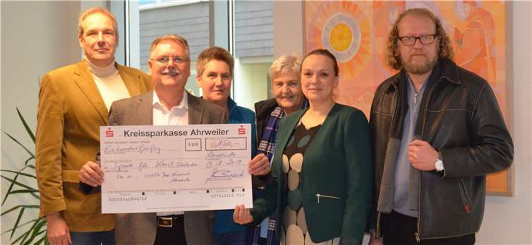 Alfons Busch (2. v. l.) und Olga Atamanova (2. v. r.) übergaben den symbolischen Spendenscheck an (v. l.) Pfarrer Thomas Rheindorf, Ulrike Hoffmann, Marion Eisler und Karl Peter Gerigk. Foto: privat