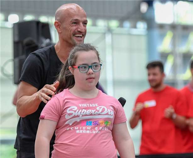 Weltweit größtes Sportfestival für Menschen mit Down-Syndrom gefeiert  Alina bei der Modenschau mit Peyman Amin. Foto: Hexal