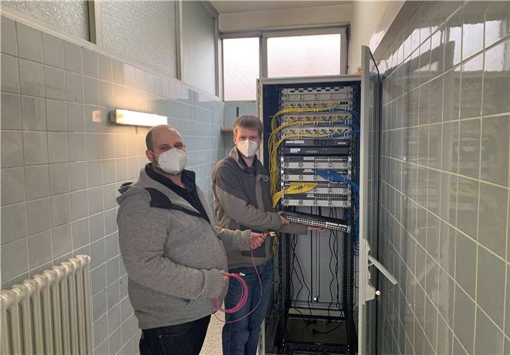 Alle 25 Schulen des Landkreises werden nach der jetzigen Planung spätestens zum neuen Schuljahr mit einer modernen IT-Infrastruktur ausgestattet sein. Das ist die Kernaussage von Landrat Achim Hallerbach und dem 1.Kreisbeigeordneten Michael Mahlert. Bis zum Sommer 2021 will der Kreis die laufenden Arbeiten abgeschlossen haben. IT-Support-Manager Sebastian Biersch (rechts) kontrolliert mit seinem Kollegen Martin Wagner die Verbindungen am Serverschrank der Maximilian-Kolbe-Schule in Rheinbrohl.Quelle: Kreisverwaltung Neuwied