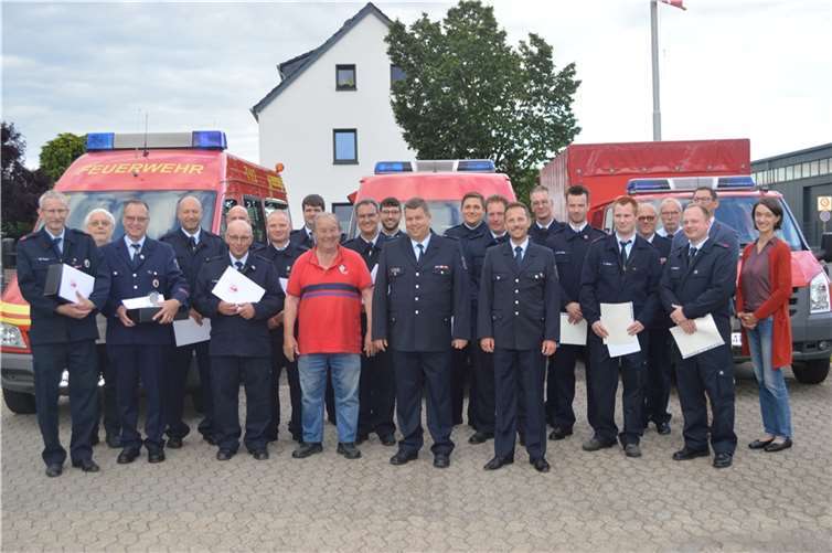 Alle Geehrten, Beförderten, Ent- und Verpflichteten auf einen Blick mit Bürgermeister Björn Ingendahl und Einheitsführer Ingo Wolf (Mitte) und Pfarrerin Johanna Karcher (r.).  Foto: AB