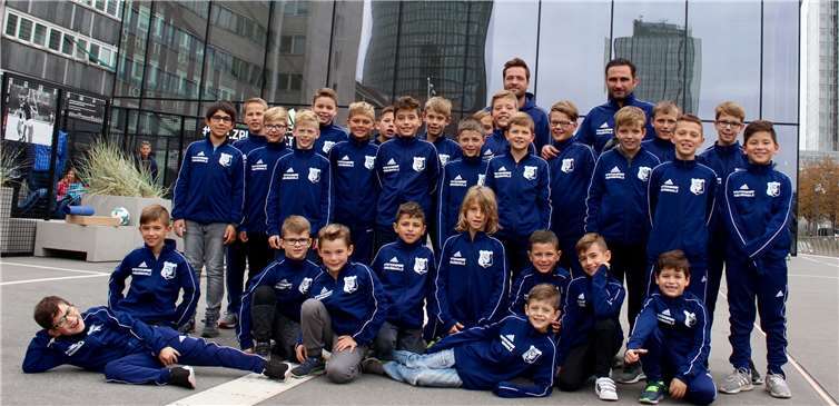 Alle Spieler der beiden Mannschaften bei der Ankunft vor dem Museum, mit FC Andernach Logo-Schriftzug im Hintergrund.