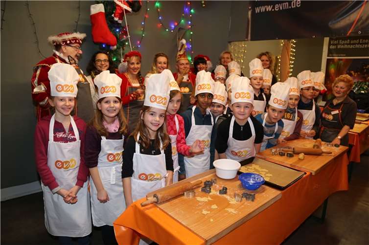 „Alle packen tatkräftig mit an und bestreuen die leckeren Mürbeteigplätzchen mit noch schmackhafteren Zuckerstreuseln.“