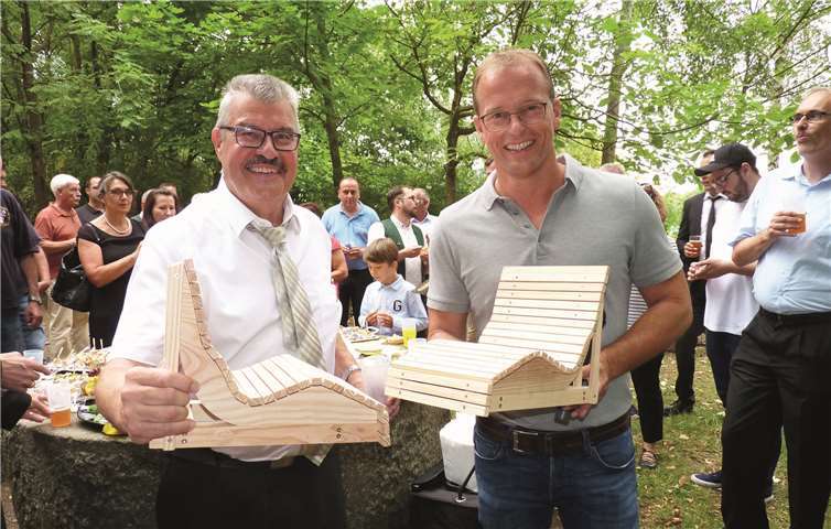 Als Zeichen einer Freundschaft, die auf dem Zusammenschluss der Stärken beider Ortsteile basiert, überreichte VG-Bürgermeister Jörg Lempertz –rechts- dem Mendiger Stadtbürgermeister Hans Peter Ammel zwei Modellbänke, deren Originale für einen Traumpfad bereit stehen.