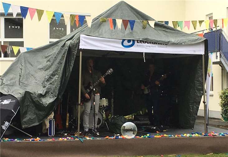 Als der Regen kam, wurde das Dach des Falafel-Standes kurzerhand über Musiker Alex Auer und seiner Begleitung aufgespannt - und die Party konnte weitergehen.