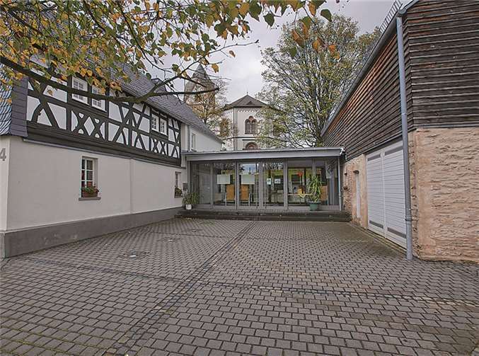 Altes mit Modernem verbunden. Links das renovierte Haus am Hochgericht, rechts die Museumsscheune mit der Kirche im Hintergrund.