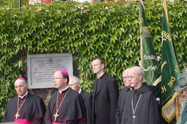 Am 23. August 2010 enthüllten Bischof Dr. Felix Genn aus Wassenach (auf dem Foto Erster von links) und Bischof Dr. Stephan Ackermann aus Nickenich (auf dem Foto Zweiter von links) die Gedenktafel zu Ehren der beiden Märtyrer-Priester Schulz und Zilliken am Waldfrieden in Wassenach. 