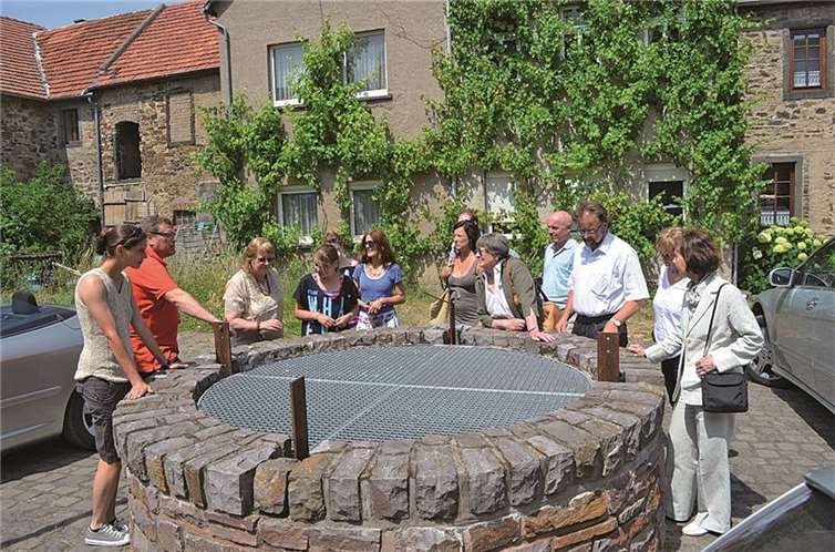 Am Brunnen vor der Propstei: Gerd Rothbrust (2. v. l.) erläutert den Teilnehmern der liberalen Kultur-Tour um Organisatorin Christina Steinheuer (l.) die Bedeutung des vorhandenen Wassers für die Besiedelung.Privat