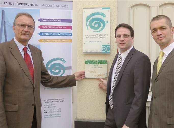 Am Eingang zum Büro der Mittelstandförderung in Neuwied haben Landrat Rainer Kaul (l.) und MFG-Geschäftsführer Harald Schmillen (M.) die neue Tafel anbringen lassen, mit der Kräuterwind-Geschäftsführer Uwe Schmalenbach die Institution ausgezeichnet hat. privat