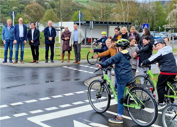 Am Projekt Beteiligte auf beiden Straßenseiten beobachten die Kinder, die die Strecke ihrer vorhergehenden Radfahrprüfung noch einmal abfuhren. Fotos: AWI