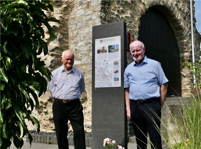 Am Wolfsturm steht eine der beiden neuen Basaltstelen. Dr. Paul Possel-Dölken (r.) und Dr. Hermann-Josef ten Haaf, stellvertretend für die Arbeitsgruppe, freuen sich, dass der historische Stadtrundgang wächst. Foto: Stadt Montabaur.