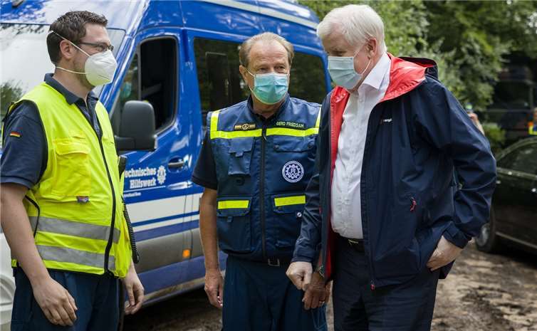 An der Einsatzstelle der Steinbachtalsperre bei Euskirchen informierte sich Bundesinnenminister Horst Seehofer (r.) bei den Ehrenamtlichen und THW-Präsident Gerd Friedsam (m.) über den Hochwassereinsatz. Foto: THW/Yann Walsdorf