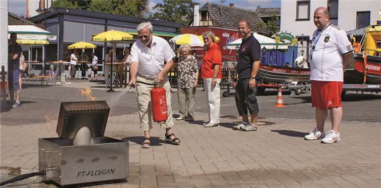 An einem eigens aufgebauten Übungsgerät konnten die Besucher testen, wie sie mit einem Feuerlöscher einen brennenden Monitor löschen. Heinz-Wolfgang Heil zeigte unter den fachkundigen Augen von Wehrführer Jakob Reif (2. von rechts) sein Können. GH
