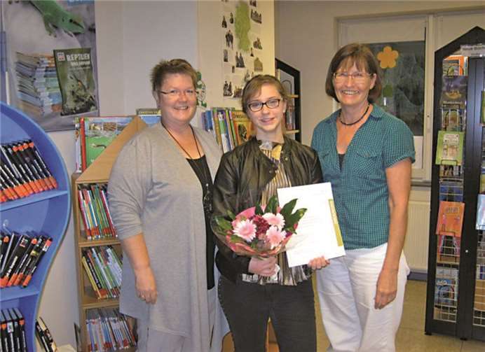 Anastasia Kopuso (M.) wurde von der Büchereileitung mit einem Blumenstrauß, einem Gutschein und einer Ehrenamtsurkunde verabschiedet. privat