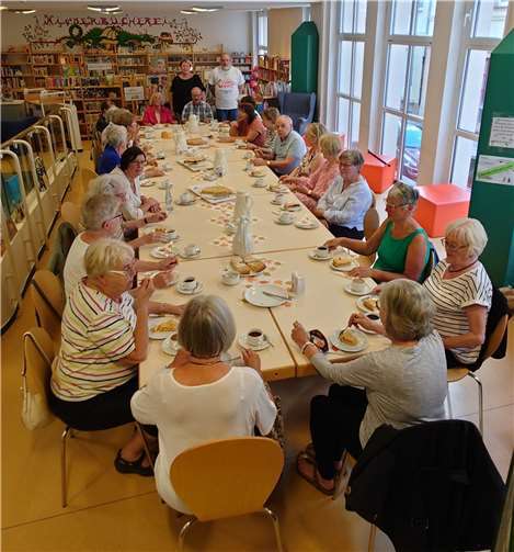 Andernacher Senioren genießen die Kaffeetafel in der Stadtbücherei. Im Hintergrund stehend Désiré Scherer und Frank Merken Foto: Richard Welter