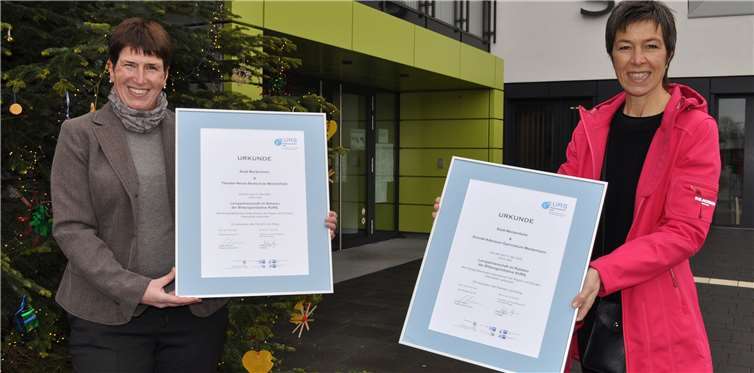 Andrea Jäger (rechts) vom KURS-Basisbüro beim Schulamt für den Rhein-Sieg-Kreis übergibt die Urkunden an Britta Röhrig, Leiterin des städtischen Fachbereichs Personal. Foto: Stadt Meckenheim
