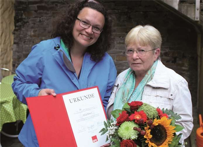 Andrea Nahles, Bundesministerin für Arbeit und Soziales, überreicht die Urkunde und einen Blumenstrauß an Helga Kittel. privat