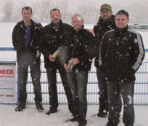 Andreas und Stefan Neideck (2.u.3.v.l.) übergaben im Schneetreiben die neue Werbebande an die SV-Vorstandsmitglieder Uwe Grabosch, Sebastian Neises und Stefan Krämer.privat