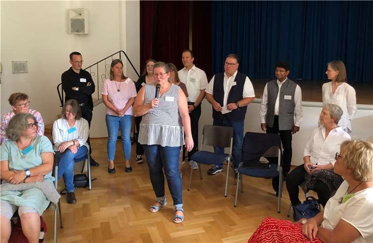 Angela Hübner vom Leitungsteam bei der Begrüßung, im Hintergrund die anderen Mitglieder des Leitungsteams und des Seelsorgeteams.