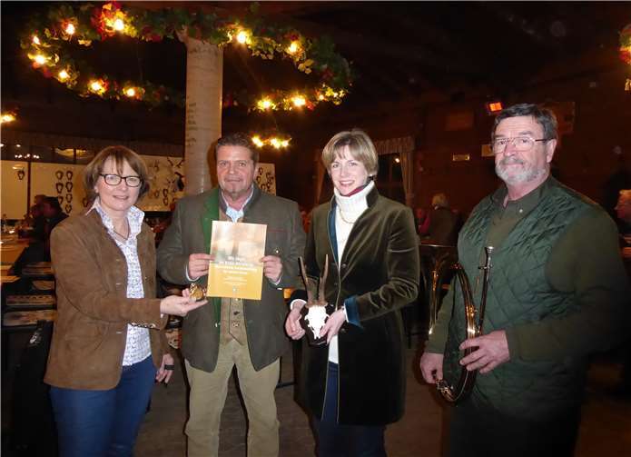 Angelika Stahl, Ralf Schmitt, Schriftführerin Ute Weiß und der Vorsitzende des Bläserchors Dr. Wolfgang Schumacher (v.l.) mit einem der prämierten Geweihe und der von den Jägern im Kreis herausgegebenen Broschüre.Foto: RU