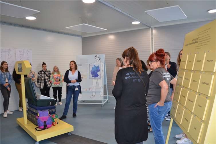 Ania Sikkes erklärt das Kofferspiel. In nur 30 Sekunden ist zu entscheiden, welche Dinge unbedingt in den Koffer müssen.