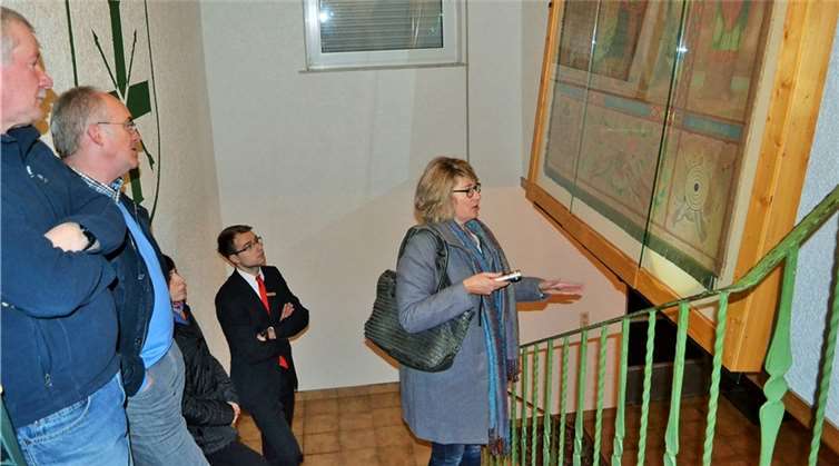 Anja Lienemann erklärt die Figuren und Symbole auf der Gründervereinsfahne.