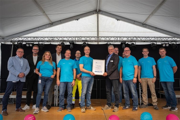Anlässlich des 50-jährigen Jubiläums des Aus- und Weiterbildungszentrums Rauschermühle überreichte Martin Neudecker, Geschäftsführer der IHK-Regionalgeschäftsstelle Mayen-Koblenz (6. v. r.), eine Jubiläumsurkunde der Industrie- und Handelskammer an Ausbildungsleiter Jan Bruhn (7. v. l.). Mit auf dem Foto: Landrat Marko Boos (2. v. l.), Westenergie-Vorstand Oliver Henrichs (4. v. l.), Betriebsratsvorsitzender Uwe Genn (links) sowie Beschäftigte und Auszubildende des Aus- und Weiterbildungszentrums.