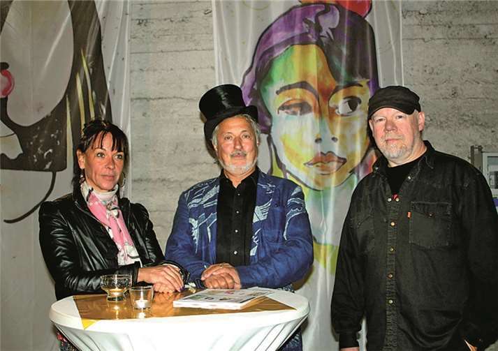 Anne und Konrad Beikircher vor einer, der im Stile „entarteter“ Kunst bemalten Flaggen.DL