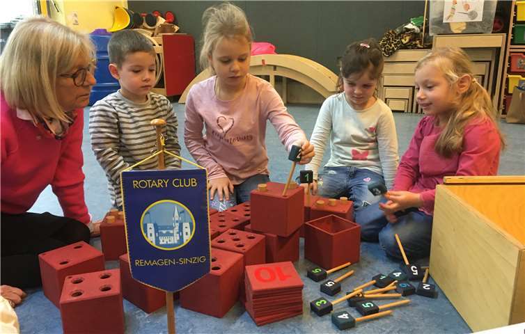 Annegret Stegers (l.), Präsidentin des Rotary Clubs Remagen-Sinzig, lernt mit den Kindern spielerisch das Addieren mithilfe der rotarischen „Mathekiste“. Foto: RC Remagen-Sinzig