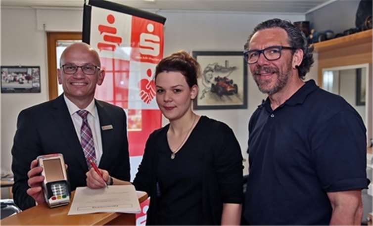 Annika und Kurt (r.) Schumacher unterzeichnen im Beisein von KSK-Marktbereichsleiter Christoph Frings die Vereinbarung zur Bargeldversorgung in Müllenbach.KSK