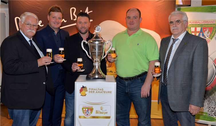 Anstoß für vier spannende Paarungen im Viertelfinale des Bitburger Rheinlandpokals: (von links) Walter Desch (Präsident Fußballverband Rheinland), Gerd Müller (Verkaufsleiter Eifel/Trier bei der Bitburger Braugruppe), die beiden „Glücksfeen“ Patrick Reifenscheidt und Ronny Weller sowie Bernd Schneider (Spielausschussvorsitzender FV Rheinland). Foto: funkbild / Bitburger