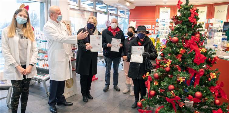 Apotheker Josef Bleif (2.v.li.) und seine Mitarbeiterin Azra Sehic (li.) überreichen die Gutscheine für jeweils einen Weihnachtsbaum an die glücklichen Gewinner Daniela Gieraths, Jutta Krause-Uellendahl und Karl-Heinz Hermann. Foto: JOST