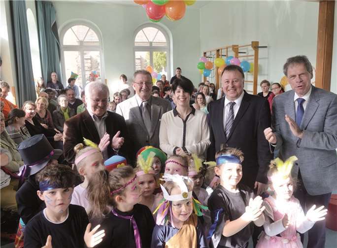 Applaus für die Kindertagesstätte in Mayschoß, wo umfangreiche Investitionen anstehen: Ulrich Jonas (Mitte von links), Hans-Dieter Kutscher, Daria Lepping, Dr. Jürgen Pföhler und Achim Haag mit Kindern und Eltern. KV-AW