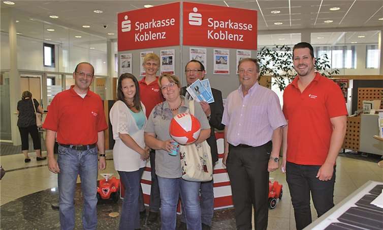 Arno Minwegen, Leiter der Sparkasse Vallendar, l., und sein Team gratulieren mit Stadtbürgermeister Gerd Jung, 2.v.r., dem Gewinner des Sparkassen-Gewinnspiels, Thomas Frank, 3.v.r.Sparkasse Koblenz
