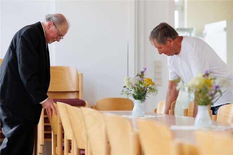 Arnold Vogel und Emil Wagner richten den Gemeindesaal her.  Foto: Peter Bongard