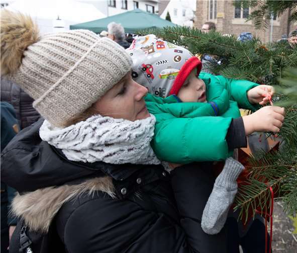 Auch Jan schmückt fleißig von Mamas Arm aus mit.