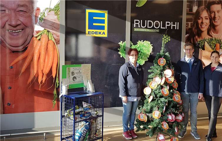 Auch in diesem Jahr unterstützt EDEKA Rudolphi mit ihrer Wunschkugelaktion das Tierheim und den Tierschutzverein im Kreis Ahrweiler, hier (v.li.n.re.): Andrea Hüppen, Patrick Mauel und Nadine Rudolphi mit einem der Weihnachtsbäume. Foto: privat